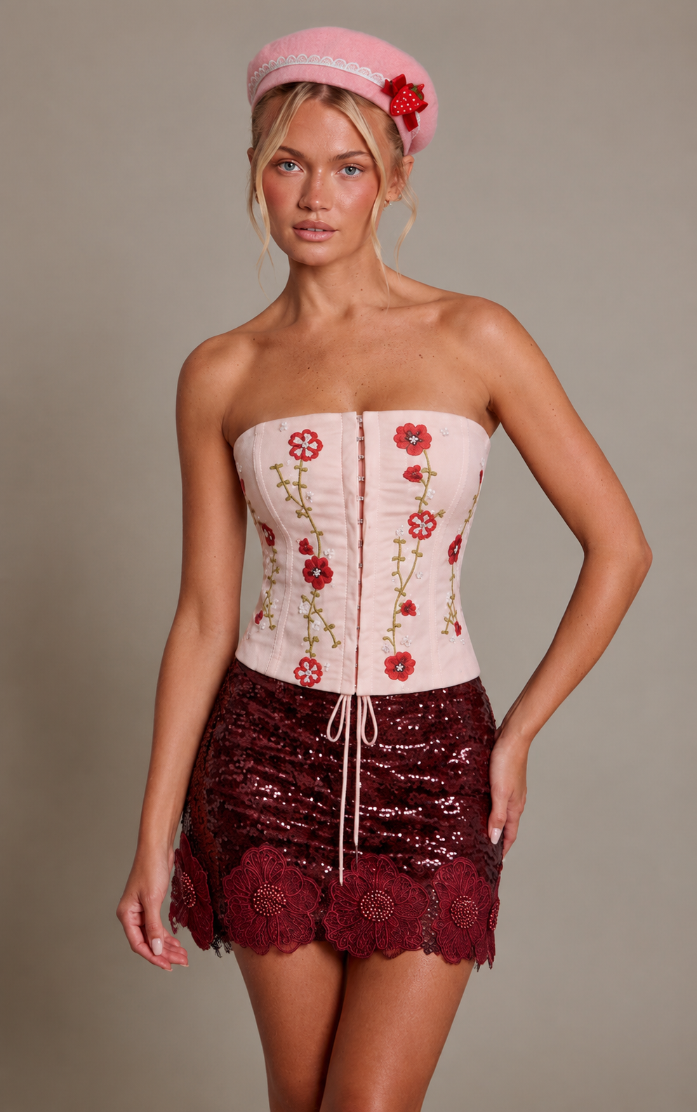 Detalle del look inspirado en Frutillita con corset rosa floral y minifalda burdeo con flores en el borde.