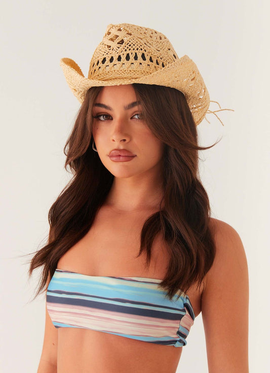 Sombrero vaquero beige con diseño calado y alas curvadas, vista frontal